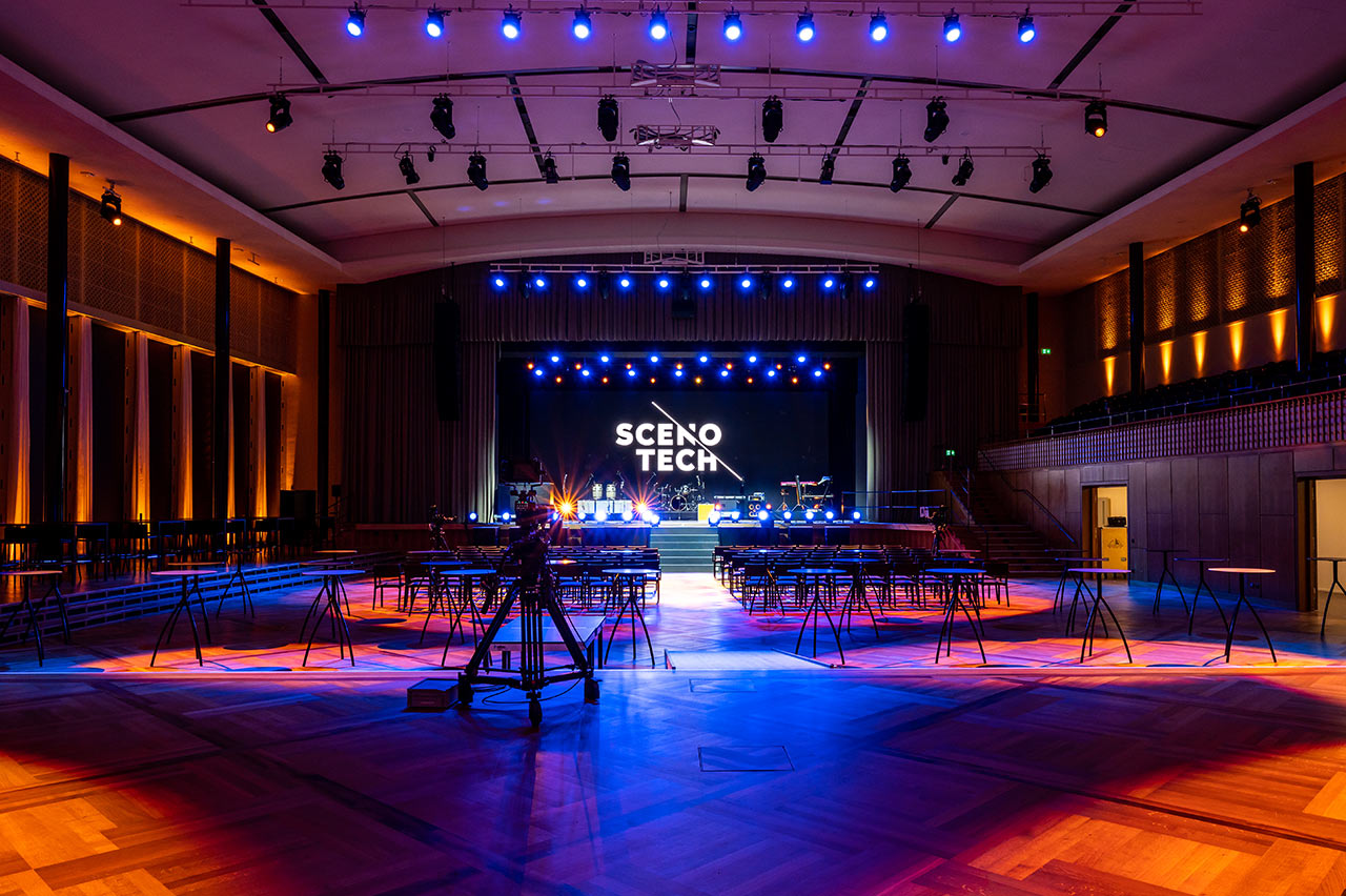 Großer Saal mit Bühne und Scenotech-Logo